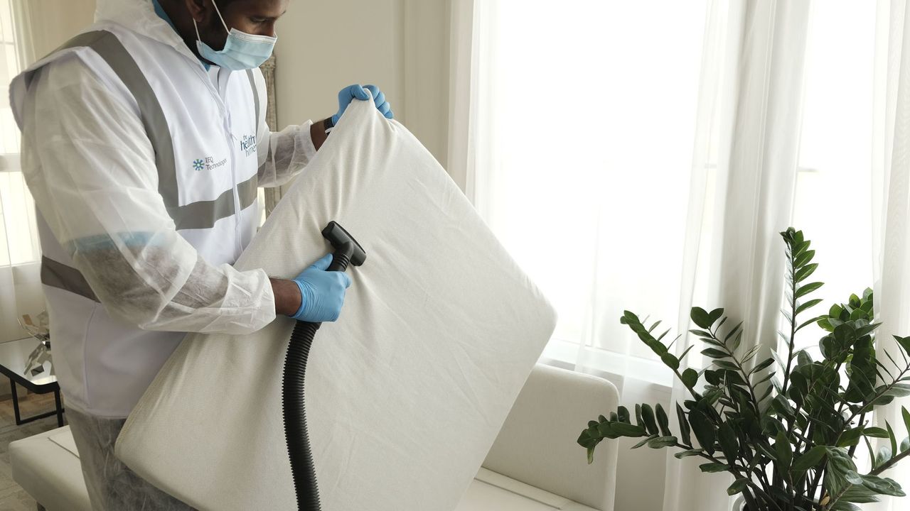 Aspiration d'un matelas en tenue de protection
